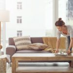 Shot of a young woman cleaning her living room